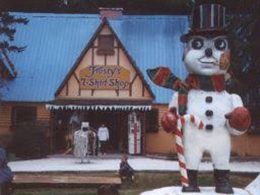 A giant snowman figure in front of a holiday-themed building.