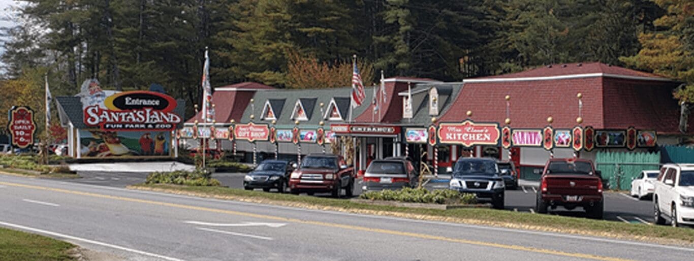 A roadside inn with an American flag and parked cars.